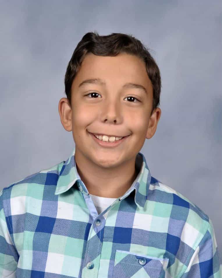School portrait of Hammer's son in a plaid shirt, smiling brightly