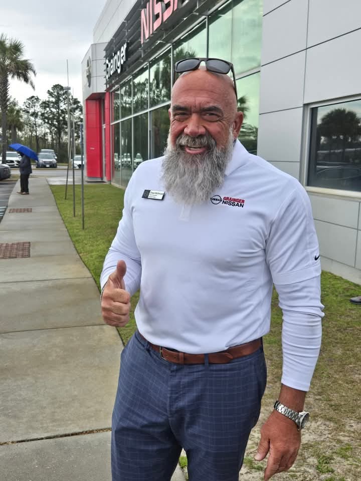 Hammer smiling and giving a thumbs up, wearing a white shirt