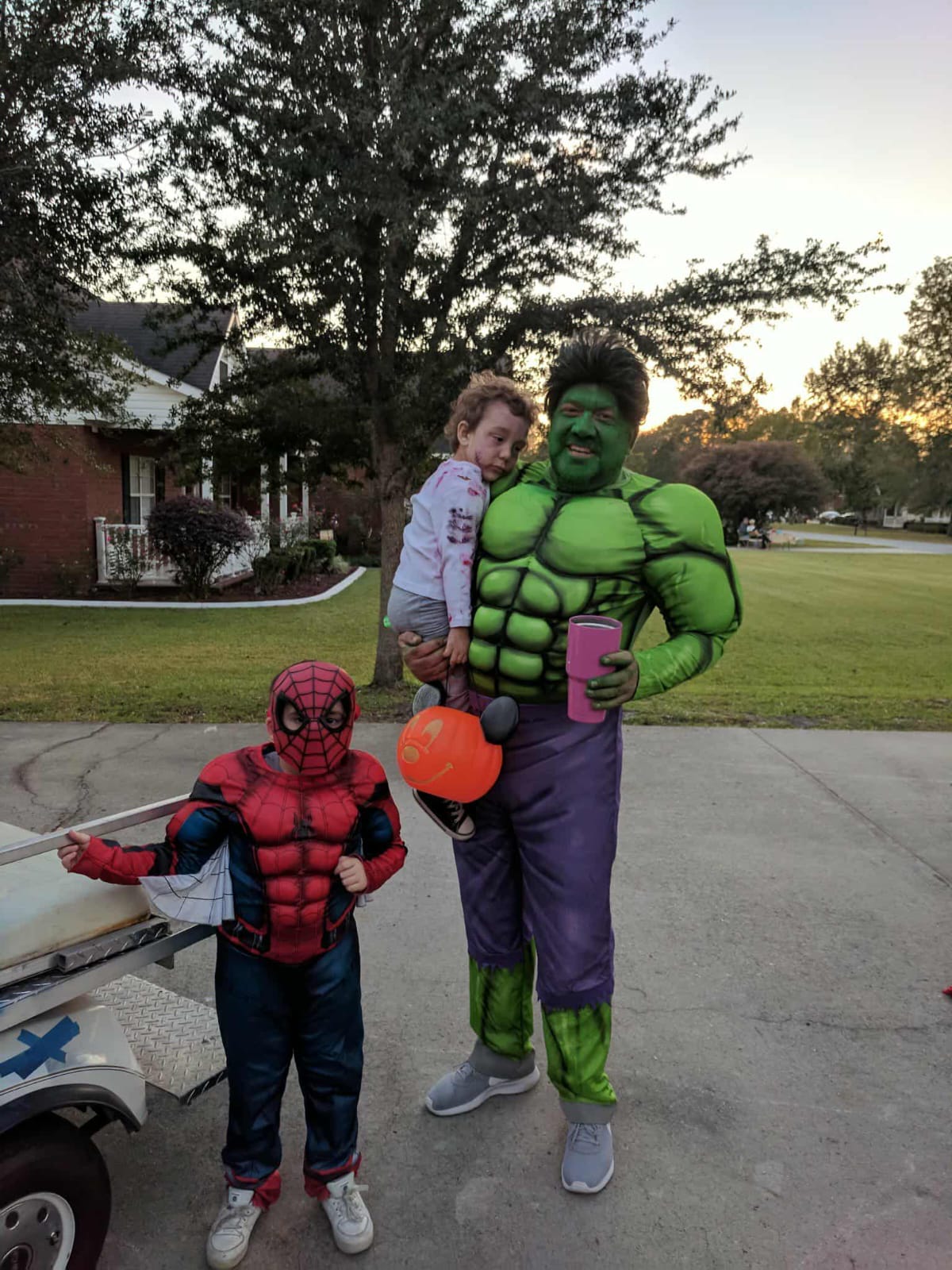Hammer dressed as the Hulk with children in superhero costumes during Halloween