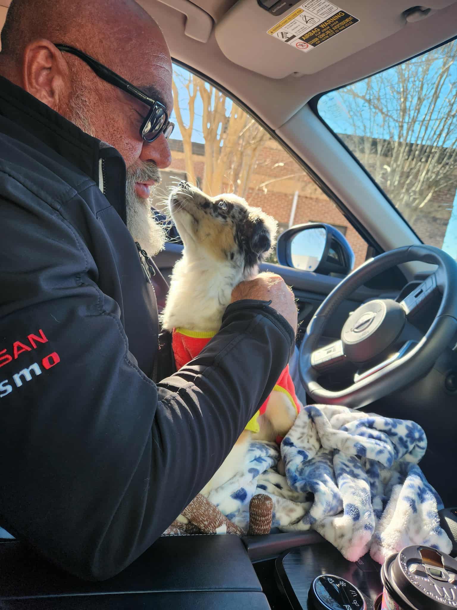 Hammer with a small dog in his car, showing his gentle and caring side