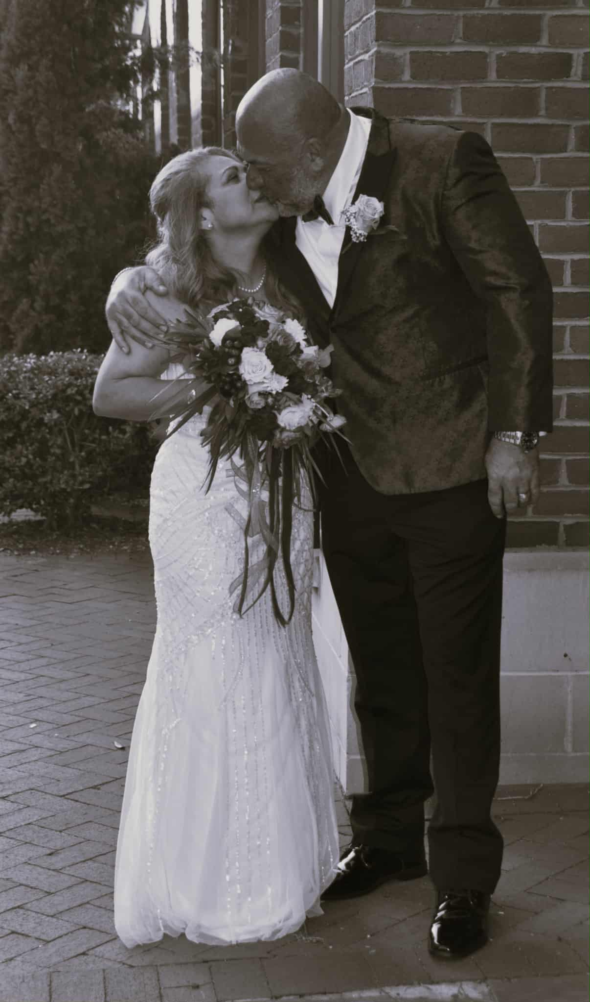 Beautiful black and white wedding photo of Hammer and his wife sharing a romantic kiss